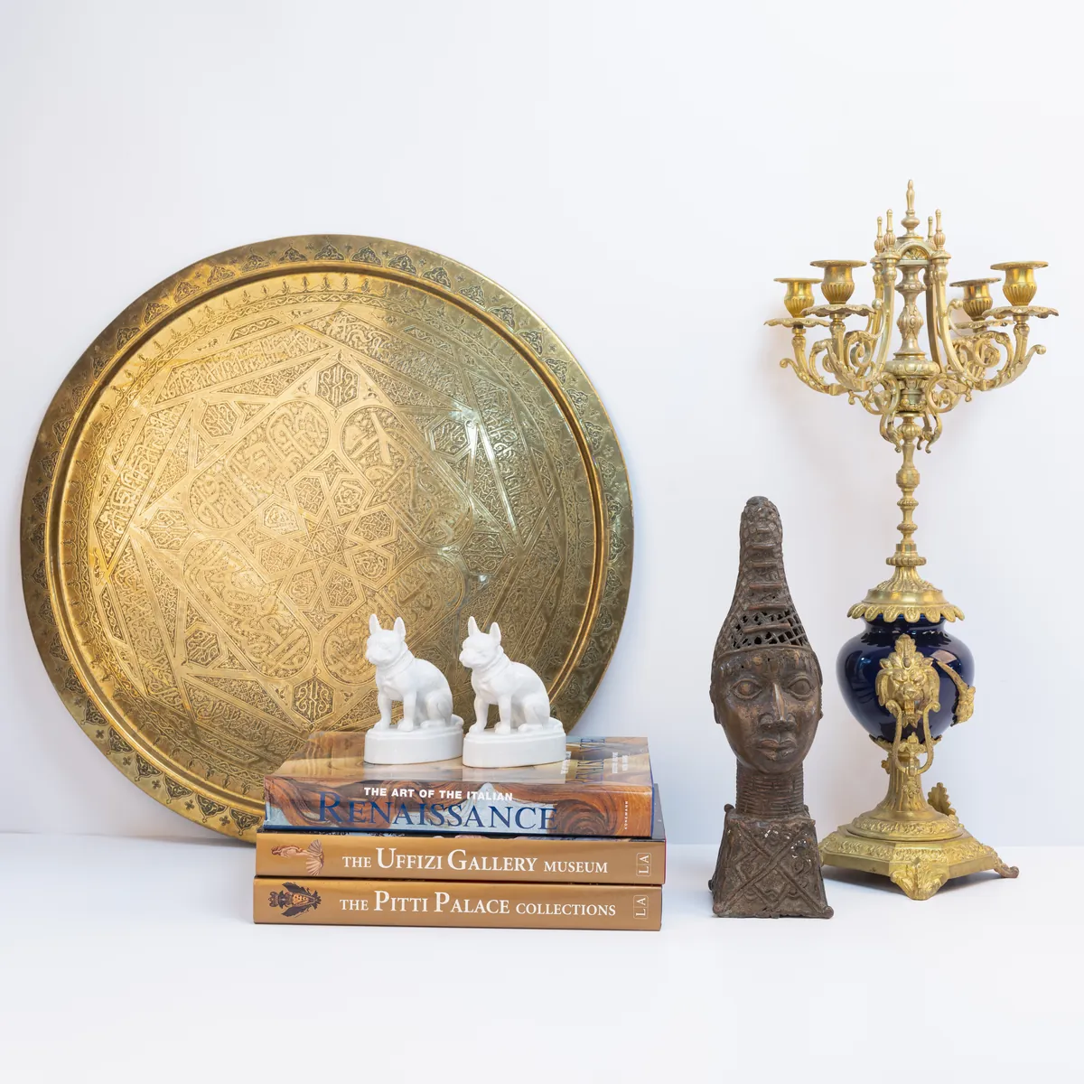 Still life of a brass tray, candelabrum, bronze head and art books. Photograph by STAS PRO