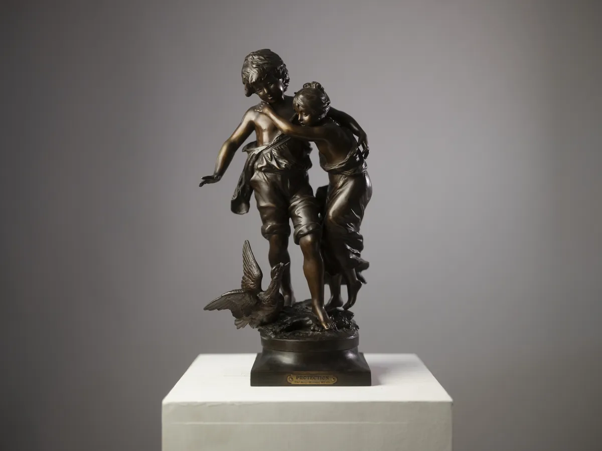 Bronze sculpture of two figures on a plinth. Photograph by STAS PRO